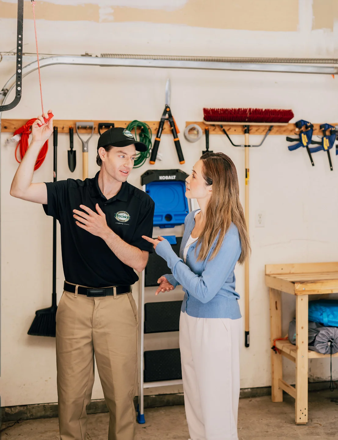 Precision Garage Door technician showing customer how to use the emergency release cord Precision Garage Door technician showing customer how to use the emergency release cord