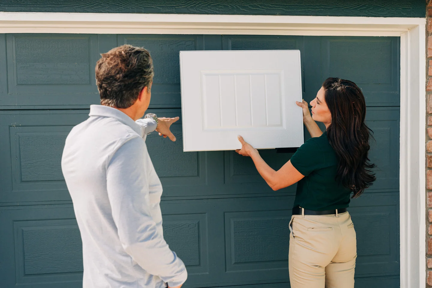 Precision sales tech showing insulated garage doors and panel options, and discussing garage door replacement cost
